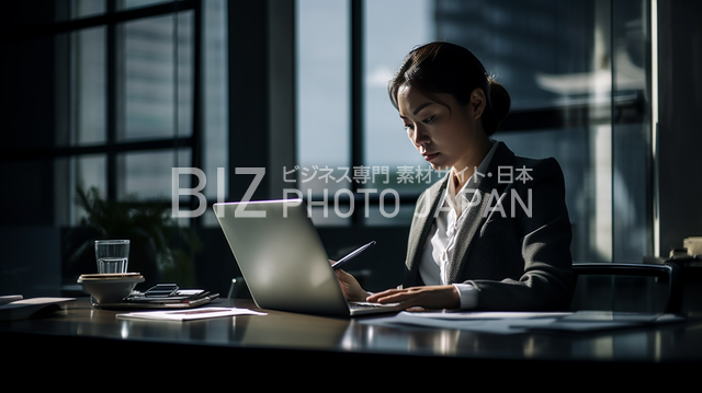オフィスデスクに座っている女性ビジネスウーマンの写真