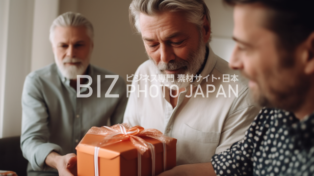 期待に胸躍る瞬間！白髪の男性がプレゼントを開ける瞬間、中年男性が期待に満ちた表情で見つめる材