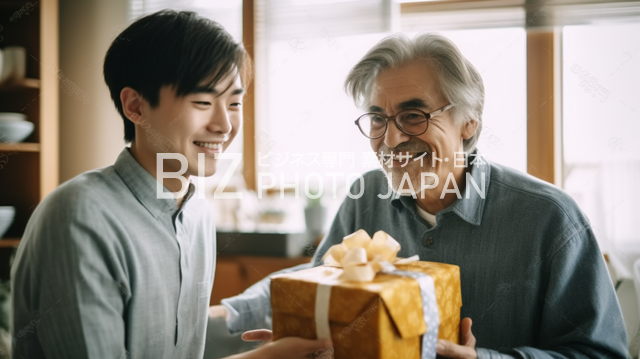 白髪の男性が20代の息子からプレゼントを受け取り喜ぶ姿