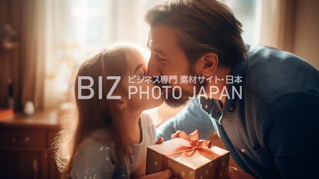 40代の男性が感謝のキスをしながら幼い娘にプレゼントを渡すシーン