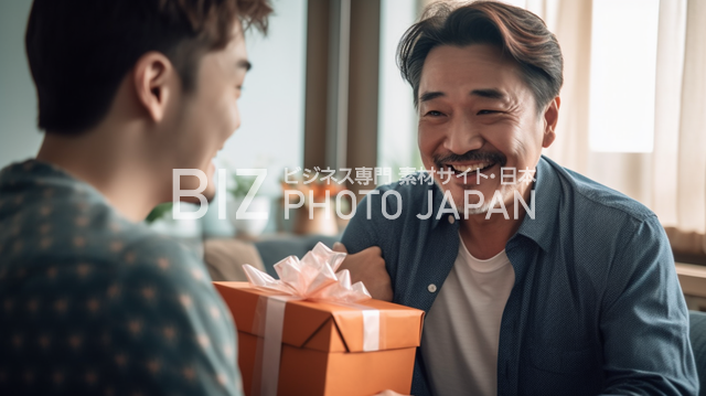 40代の男性が20代の男性からプレゼントを受け取った瞬間、20代の男性が笑顔で拍手する感動のシーン