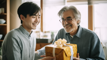 白髪の男性が20代の息子からプレゼントを受け取り喜ぶ姿